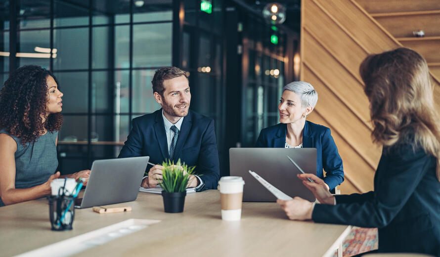 Group of business persons sitting around a table and talking